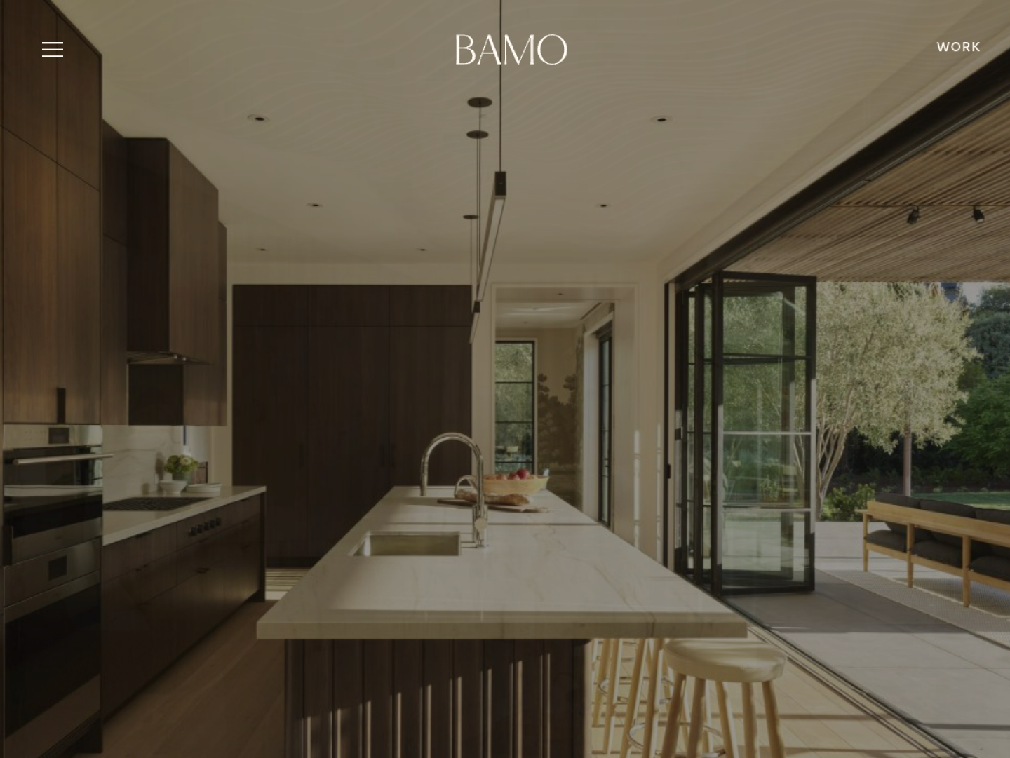 BAMO homepage, with a full-bleed photo of a kitchen opening onto a garden and only the logo and menu on top